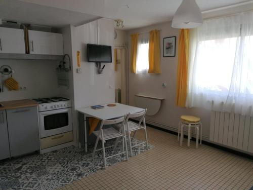 une cuisine avec une table, des chaises et une cuisinière dans l'établissement 21 rue Thomas Illyriscus, à Arcachon
