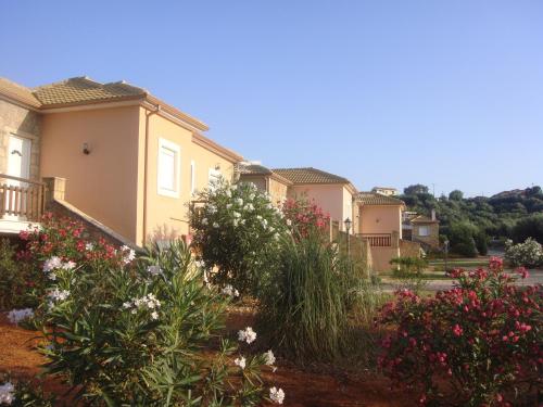 a row of houses in a town with flowers at Navarone Villas in Petrokhorion