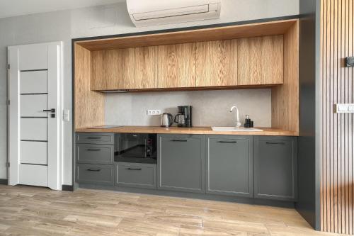 a kitchen with gray cabinets and a sink at Apartamenty Solaris in Darłówko
