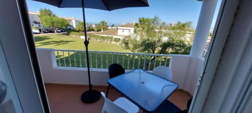 - un balcon avec un parasol et une table dans l'établissement Baia Village - Praia do Castelo - Galé - Albufeira, à Albufeira