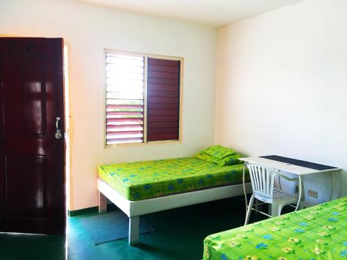 a bedroom with a bed and a desk and a window at African Symbol Guest House in Montego Bay