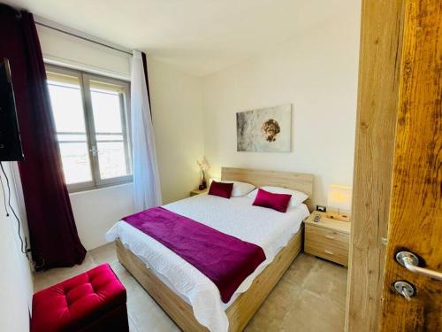 a bedroom with a large bed with a purple blanket at Smeralda Sea View - Luxury Apartment in Olbia