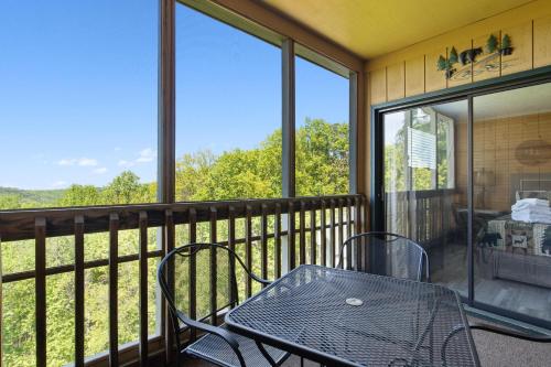 a screened in porch with a table and chairs at Ski View Mountain Resort 305, 2 Bedrooms, Mountain Views, WiFi, Sleeps 6 in Gatlinburg