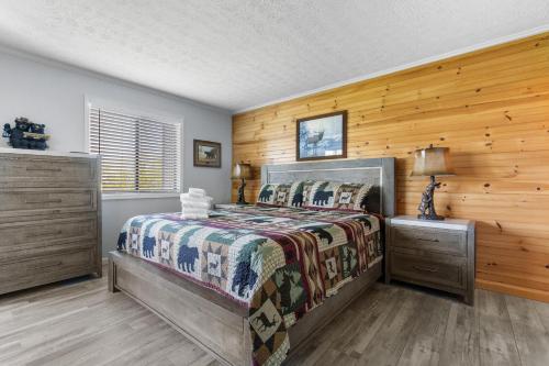 a bedroom with a bed and a wooden wall at Bear Cub Retreat in Gatlinburg