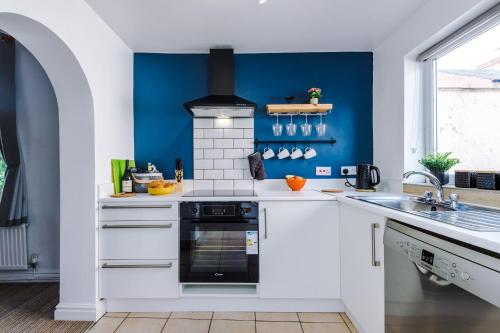 a kitchen with white counters and a blue wall at Talbot House in Chester