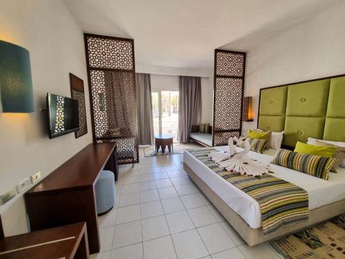 a hotel room with a large bed and a desk at Monarque Club Rivage - VV in Monastir