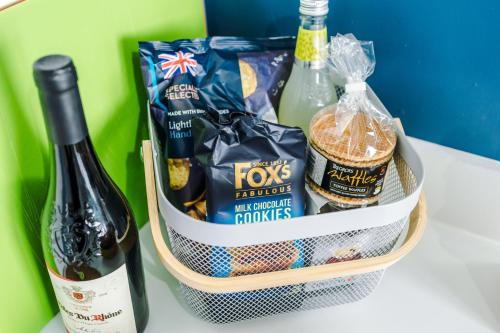 a basket filled with snacks and a bottle of wine at Talbot House in Chester