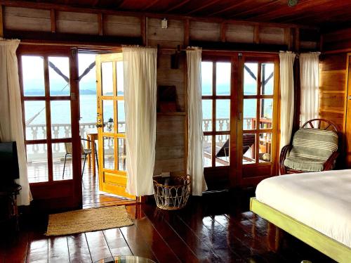 Schlafzimmer mit einem Bett und Glasschiebetüren in der Unterkunft Casa Acuario Boutique Hotel in Bocas del Toro