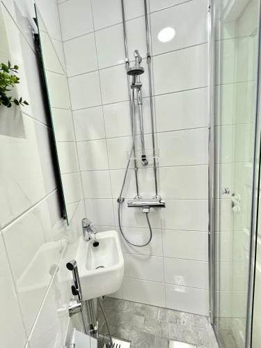 y baño con lavabo y ducha. en Renovated studio Töölö, en Helsinki