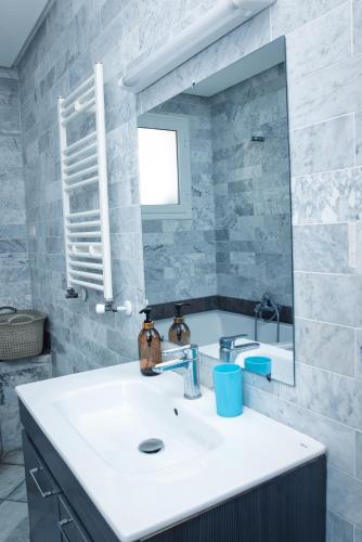 a bathroom with a white sink and a mirror at The Pearl Apartment Hammam Sousse WIFI in Sousse