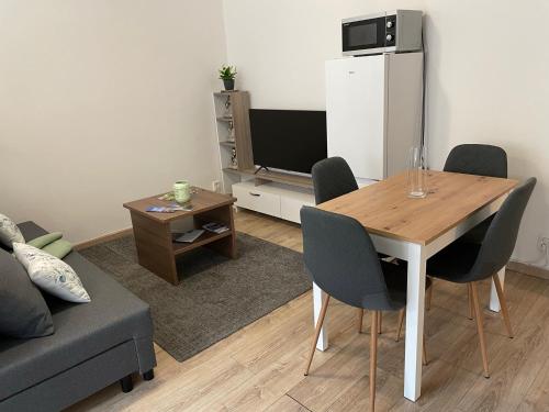 uma sala de estar com uma mesa e um frigorífico em Beroun apartments em Beroun