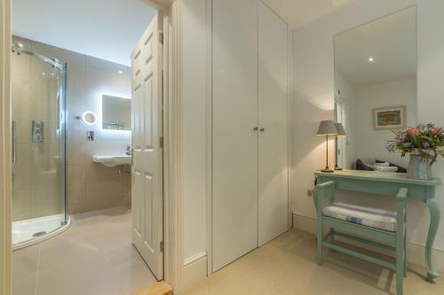 a bathroom with a sink and a shower and a chair at Beech House in Little Walsingham