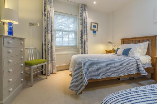 a bedroom with two beds and a dresser and a window at Beech House in Little Walsingham