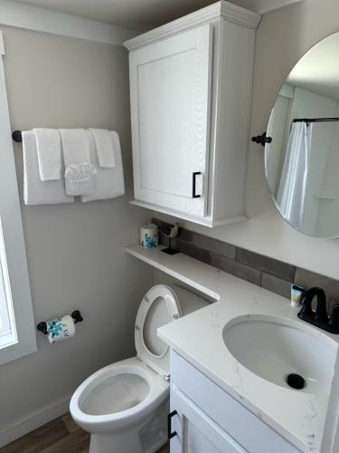 La salle de bains est pourvue d'un lavabo, de toilettes et d'un miroir. dans l'établissement Gulf Shores RV Resort, à Gulf Shores