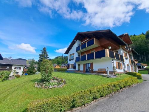 une grande maison avec une cour verdoyante dans l'établissement Ferienwohnung Helene, à Sibratsgfäll