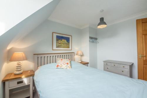 a bedroom with a white bed and a wooden table at Bosky House in South Creake