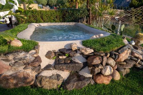 a small swimming pool with rocks around it at Villa Zagara Garden Spectacular Sea View in Taormina in Taormina