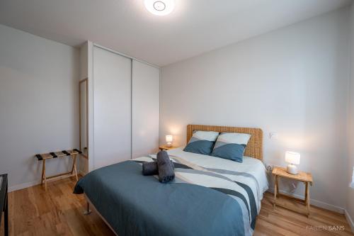 1 dormitorio con 1 cama grande y 2 lámparas en Le Saint Exupéry - T3 Centre Ville Avec Balcon + Parking Gratuit en Toulouse
