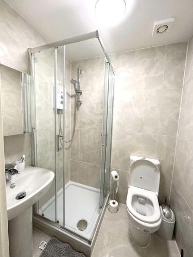 a bathroom with a shower and a toilet and a sink at Modern Double Room in Kensington Central London in London