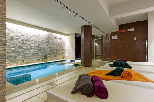 a hotel room with a swimming pool and towels at Europa Hotel Design Spa 1877 in Rapallo