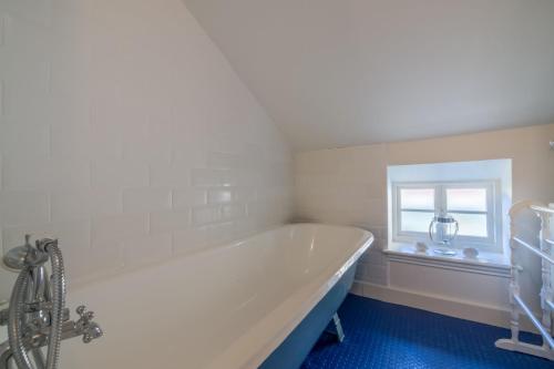 a white bath tub in a bathroom with a window at Mulberry Cottage in Wells next the Sea