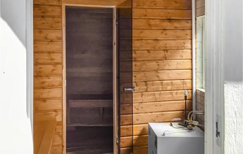 een badkamer met een houten muur en een wastafel bij Beautiful Home In Gvle With Sauna in Gävle