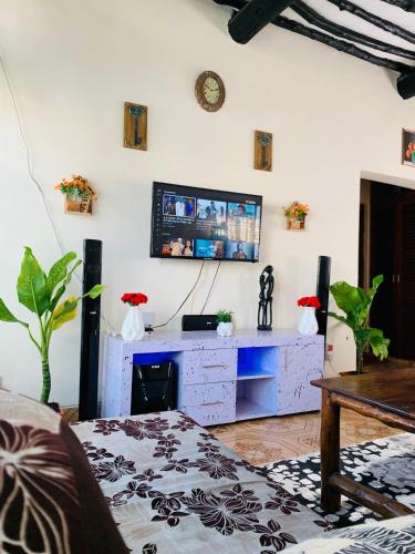 Jambo Diani 1-bedroom apartment close to the beach في شاطئ دياني: غرفة معيشة مع تلفزيون على الحائط