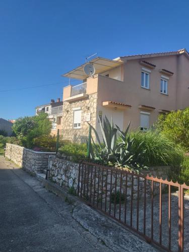 a house with a fence in front of it at Apartment Grabar in Cres