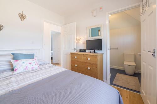 a bedroom with a bed and a television in it at Wyndham Beach House in Walcott