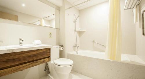 a bathroom with a toilet and a sink and a tub at Inn Hotel Macau in Macau