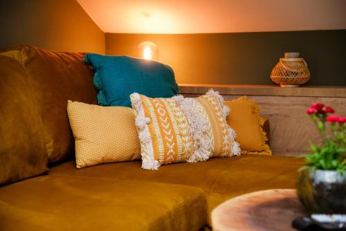 um sofá castanho com almofadas em Green Home - Lamela 1 Tivat em Tivat