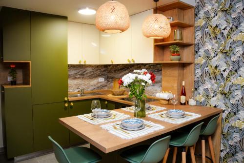 uma cozinha com uma mesa de madeira e armários verdes em Green Home - Lamela 1 Tivat em Tivat