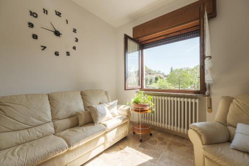 a living room with a couch and a clock on the wall at Il Cerro - Sarnico in Sarnico