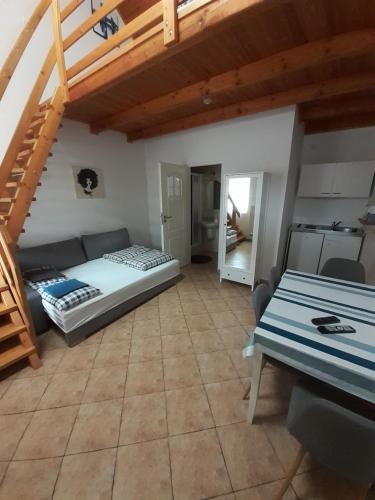 a living room with a bed and a staircase at Polonia Apartman in Egerszalók