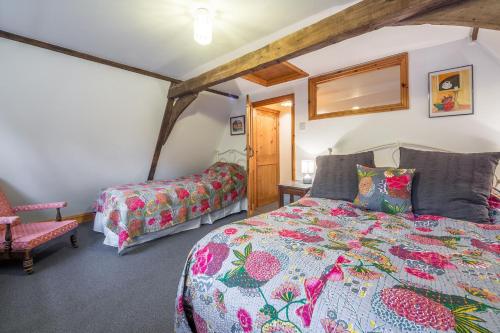 a bedroom with a king sized bed and a chair at Newgates Cottage in Wells next the Sea