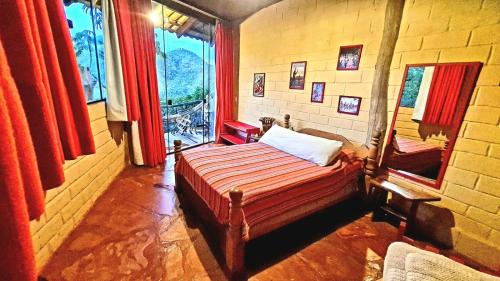 a bedroom with a bed in a room with red curtains at Ecopousada Toca do Guará in Alto Paraíso de Goiás