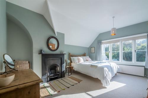 a blue bedroom with a bed and a fireplace at Station House in Helhoughton