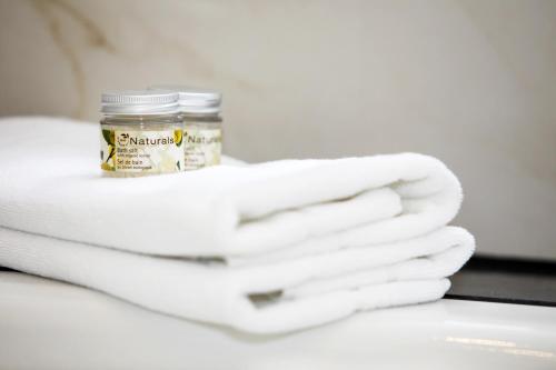 a stack of white towels and a jar of supplements at Schlosshotel Karlsruhe in Karlsruhe