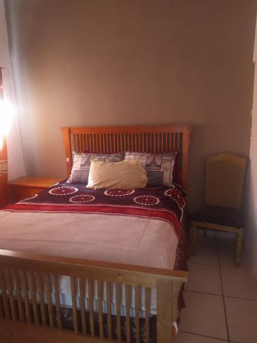 1 cama con cabecero de madera en un dormitorio en Departamento familiar accesible , cerca del consulado y centros comerciales en Ciudad Juárez