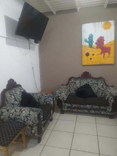 ein Wohnzimmer mit 2 Sofas und einem Flachbild-TV in der Unterkunft Departamento familiar accesible , cerca del consulado y centros comerciales in Ciudad Juárez