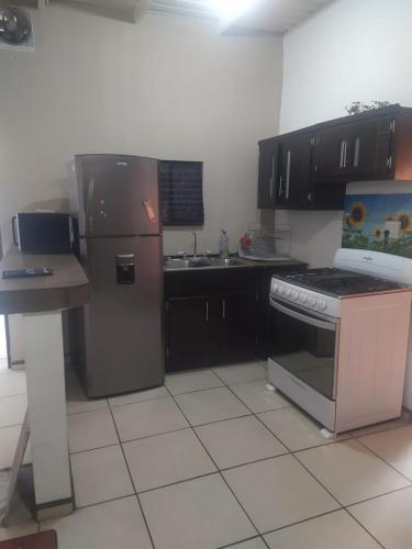 eine Küche mit einem Kühlschrank aus Edelstahl und einer Spüle in der Unterkunft Departamento familiar accesible , cerca del consulado y centros comerciales in Ciudad Juárez