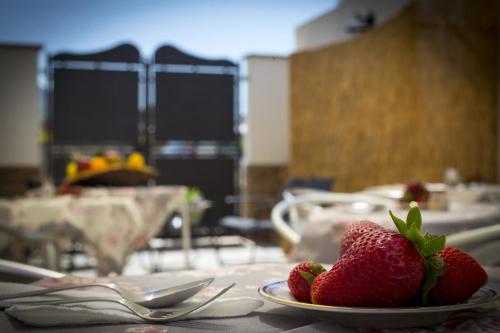 two strawberries on a plate on a table at B&B Piano di Sopra in San Vito lo Capo