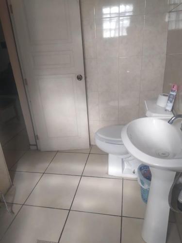 a white bathroom with a toilet and a sink at Departamento familiar accesible , cerca del consulado y centros comerciales in Ciudad Juárez