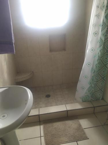y baño con cortina de ducha y lavamanos. en Departamento familiar accesible , cerca del consulado y centros comerciales en Ciudad Juárez