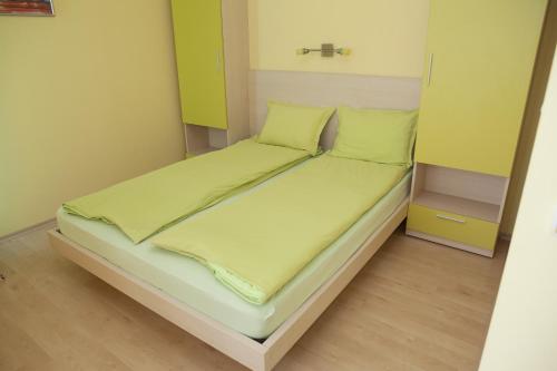 Cama en habitación con paredes amarillas y verdes en Spa Villa Crystal, en Hisarya
