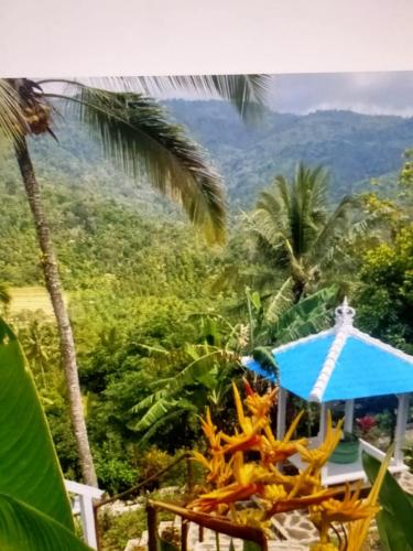 a view of the mountains from a resort with a blue umbrella at Ling & Louie's Mountain in Mayong