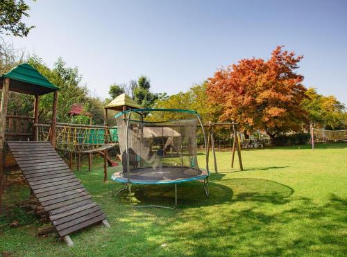 a playground in a park with a swing set at Golden Candle Guest House in Roodepoort