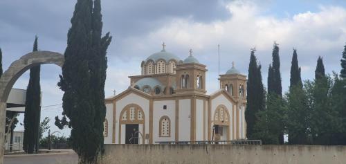 a large whitechurch with a fence in front of it at STEFARIS PROPERTIES 'sioukris court' in Larnaka