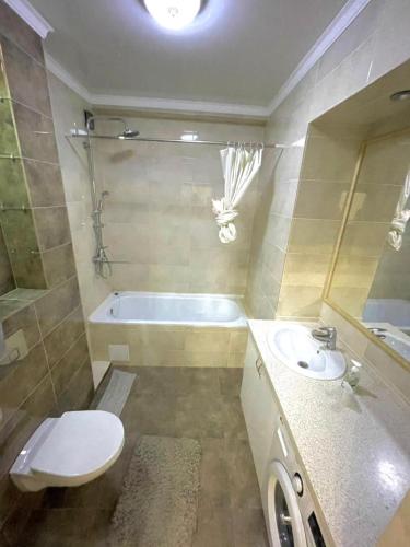y baño con bañera, aseo y lavamanos. en Elite apartment in street Moskovskay 191, en Bishkek