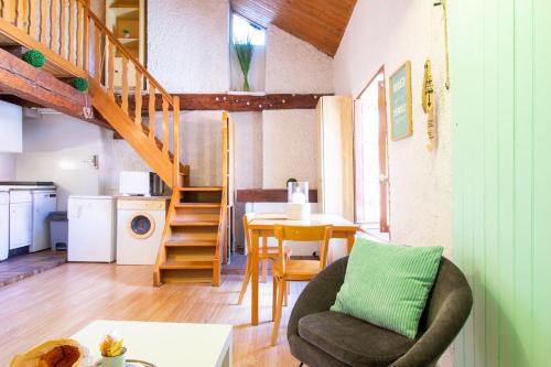 un salon avec un escalier et une table avec une chaise dans l'établissement Perle du lac au coeur de la vieille ville, à Annecy